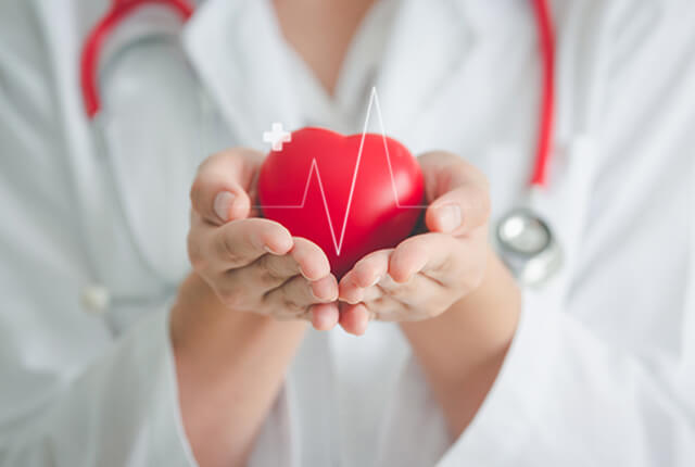 医師が心臓をイメージしたハートを両手で包み込んでいる様子